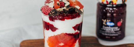 Vasito de yogur con mermelada de frambuesas, pomelo y chocolate negro